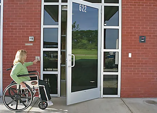 Automatic handicap door opener being installed for accessibility compliance.